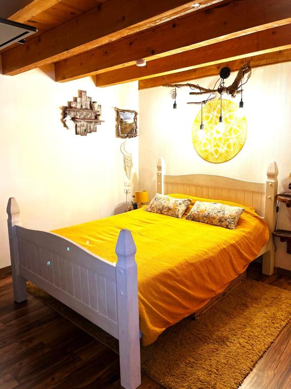 - une chambre dotée d'un lit avec des draps jaunes et un lustre dans l'établissement Cozy mini house with beautiful views, à Eygliers