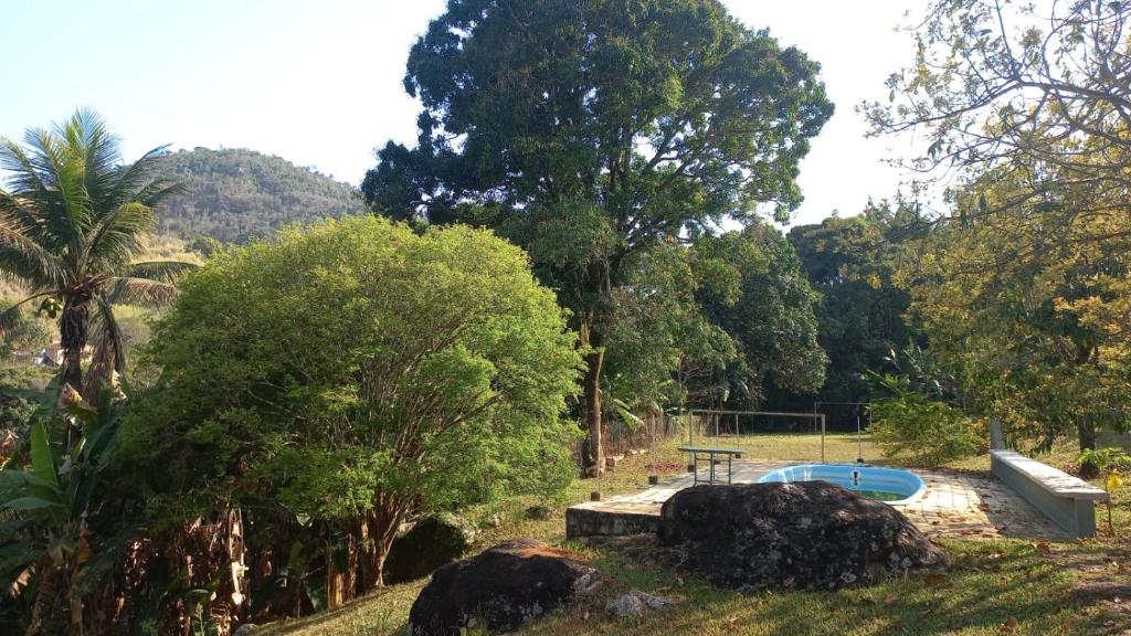 una piscina con tavolo da picnic e alberi di Sítio das Pedras - Natureza e Tranquilidade a Matias Barbosa