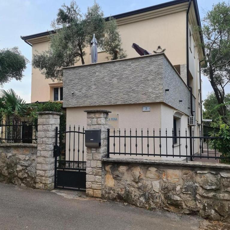 a house with a gate and a fence at Apartments Tena in Rovinj