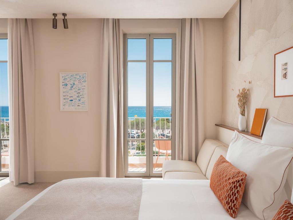 a bedroom with a bed and a view of the ocean at Hôtel Liautaud Rooftop Cassis in Cassis