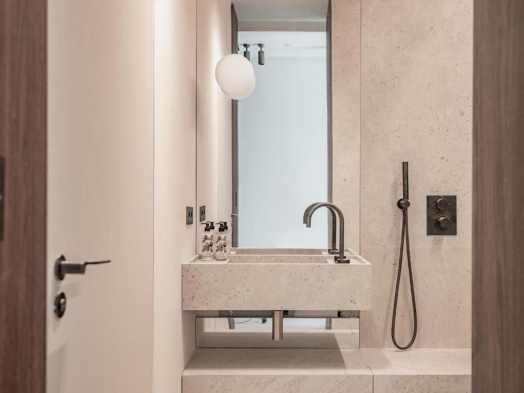 a bathroom with a sink and a mirror at Hôtel Liautaud Rooftop Cassis in Cassis