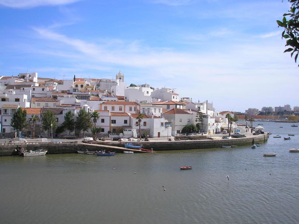 un grupo de edificios y barcos en una masa de agua en Spacious Apartment in Old Ferragudo Village, en Ferragudo