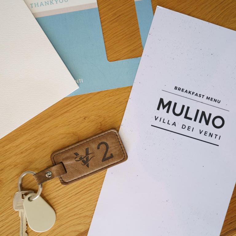 a key on a table with ailla deventer card at Villa dei Venti in Qala