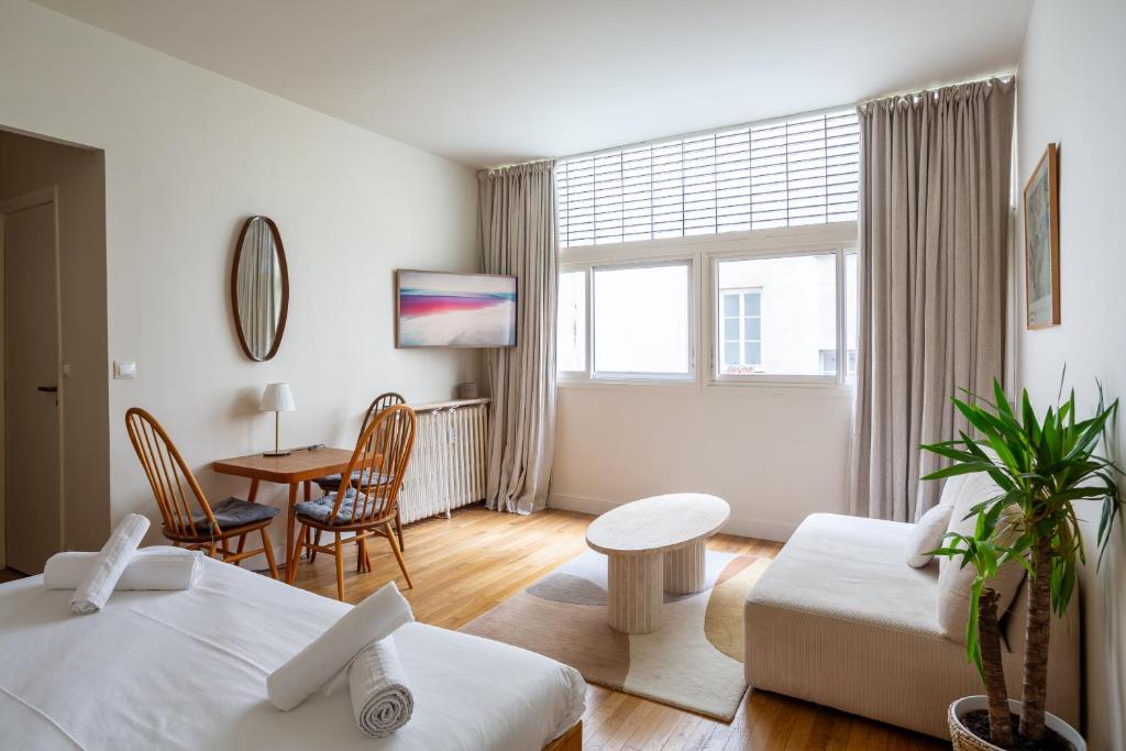 - un salon avec deux lits, une table et un canapé dans l'établissement The Charming Saint Honoré, à Paris
