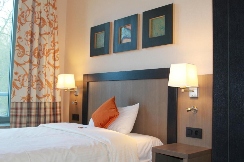 a hotel room with a bed and two lamps at Castel de Pont-a-Lesse in Dinant