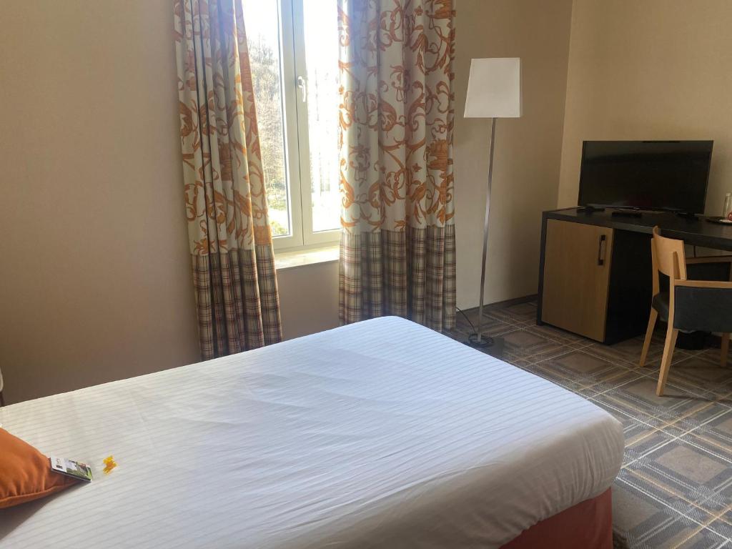 a bedroom with a bed and a window and a desk at Castel de Pont-a-Lesse in Dinant