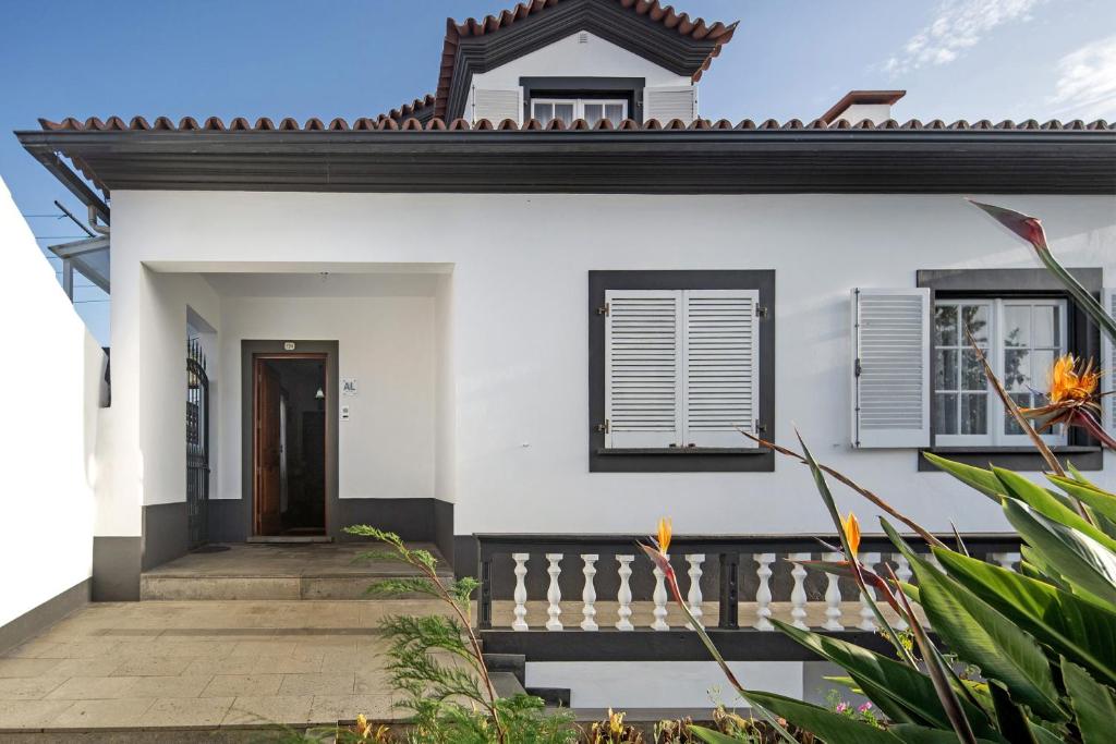 a white house with a door and a fence at Bettencourt 2 Rooms in Santa Cruz da Graciosa