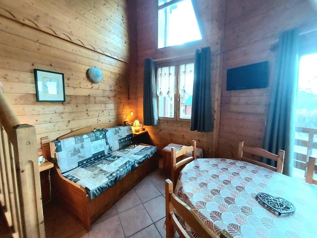 une chambre avec deux lits dans une cabane en rondins dans l'établissement Appartement 2 pièces + mezzanine, balcon, 6 pers, Plagne Soleil, près des pistes - FR-1-351-151, à La Plagne Tarentaise