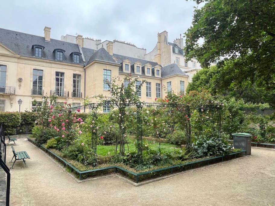 un jardin en face d'un grand bâtiment dans l'établissement Comfort & design 2 BR near Place des Vosges, à Paris