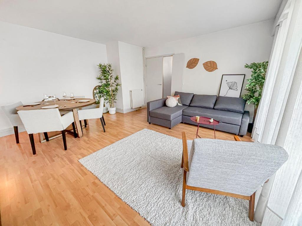 un salon avec un canapé et une table dans l'établissement Pause Paisible à Rueil-Malmaison, à Rueil-Malmaison