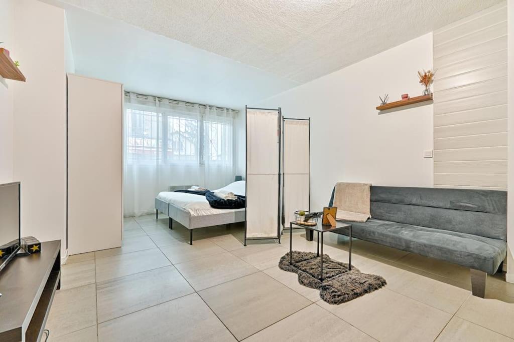 un salon avec un canapé et un lit dans l'établissement Welcome to Studio Bianca, au Blanc-Mesnil