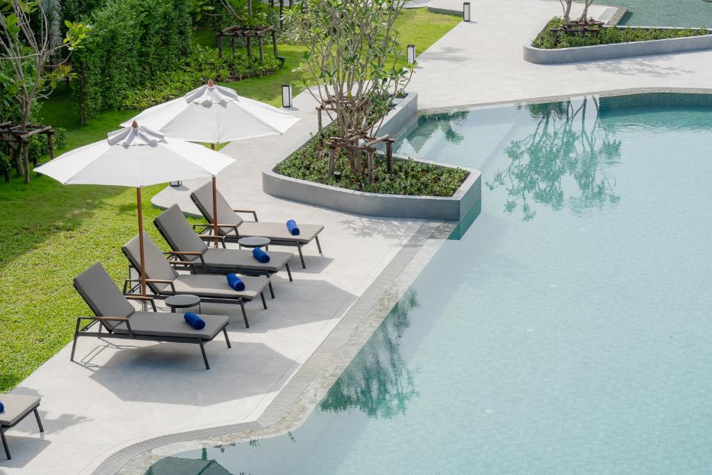 a group of chairs and umbrellas next to a swimming pool at Amari Koh Samui in Chaweng