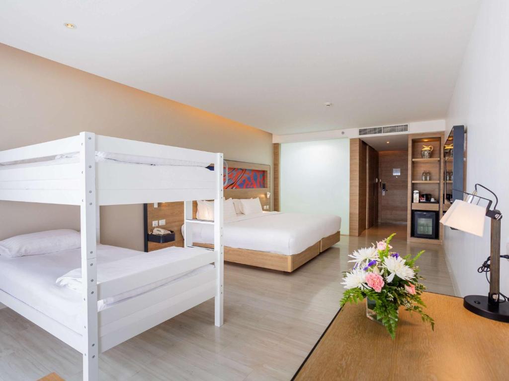 a bedroom with two bunk beds and a room at Novotel Phuket City Phokeethra in Phuket Town