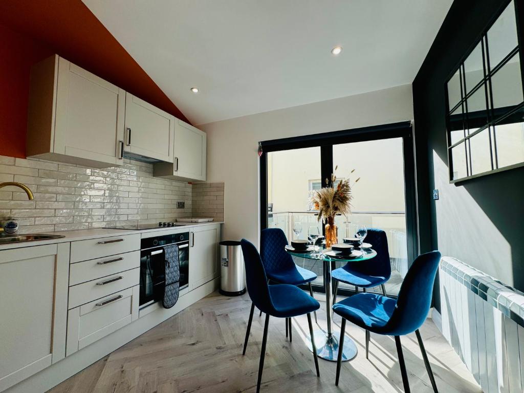 une cuisine avec une table et des chaises bleues dans une cuisine dans l'établissement Central One Bedroom Flat Next to Brighton Beach I Sleep 5 Guests, à Brighton et Hove
