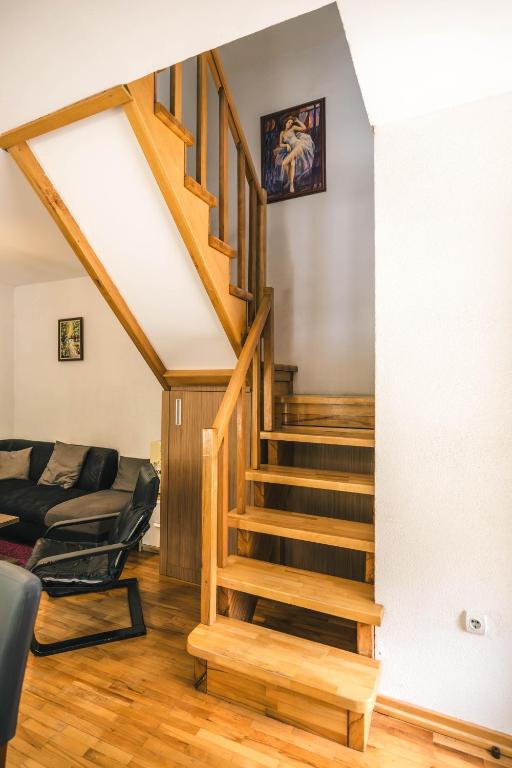 a living room with a staircase and a couch at Lodge Zeleni svet in Crni Vrh