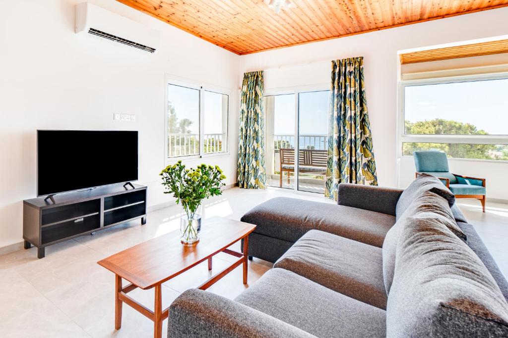 ein Wohnzimmer mit Sofa und Fernseher in der Unterkunft Villa Bettina By Ezoria Villas in Coral Bay