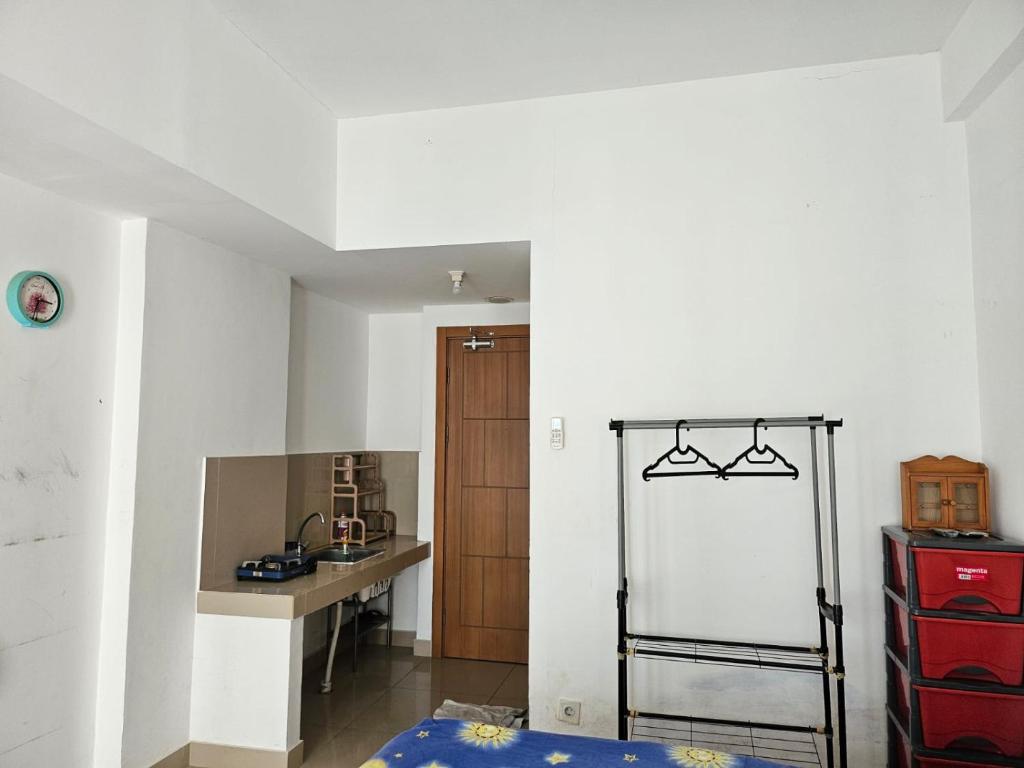 Zimmer mit einer Küche mit einem Tisch und einem Kühlschrank. in der Unterkunft Apartemen The Nest in South Tangerang
