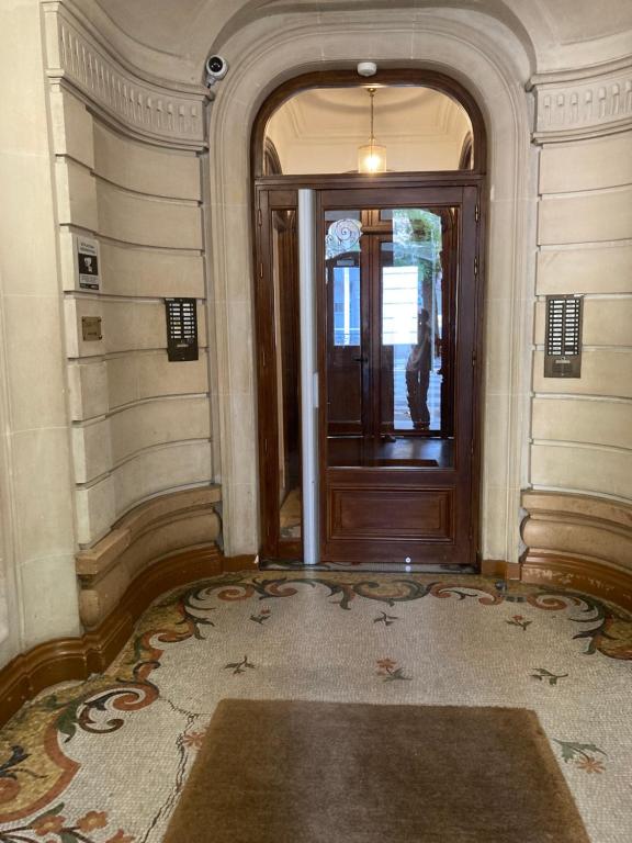 - un couloir avec une porte en bois et un tapis dans l'établissement Charmant Appartement à Montmartre, à Paris