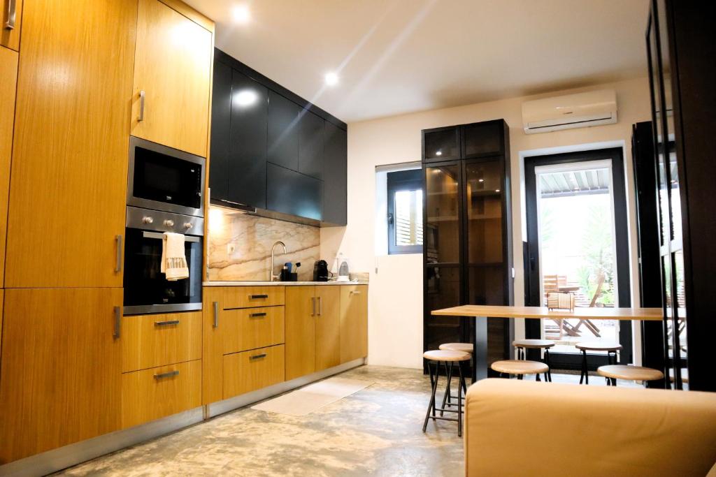 een keuken met houten kasten en een tafel met krukken bij Francos Family House in Porto