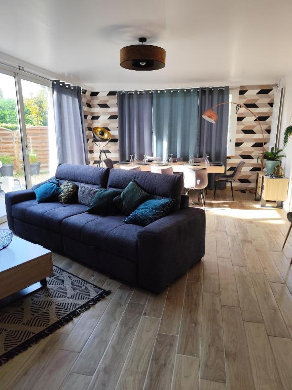 un salon avec un canapé bleu et une table dans l'établissement Maison de ville avec extérieur au calme., au Havre