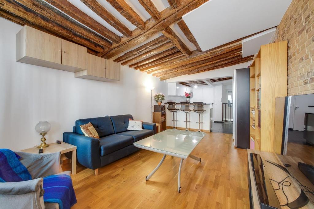 un salon avec un canapé bleu et une table dans l'établissement Montorgueil City Center, à Paris