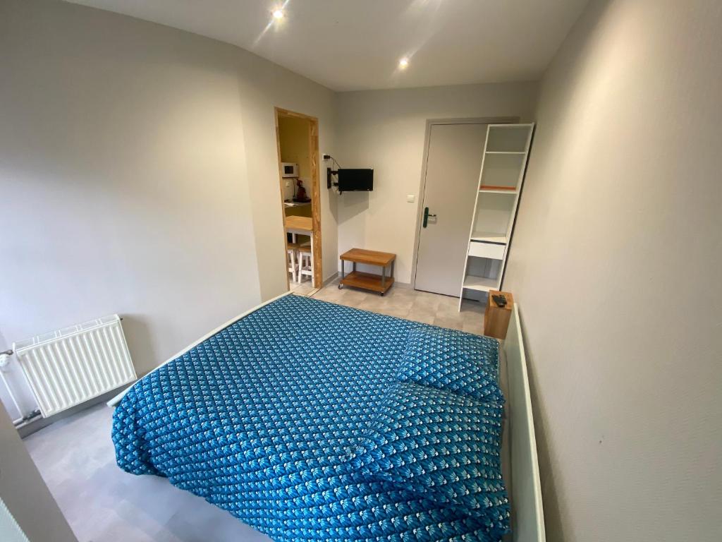 ein Schlafzimmer mit einem blauen Bett in einem Zimmer in der Unterkunft studio 5- les moulins in Cherbourg en Cotentin