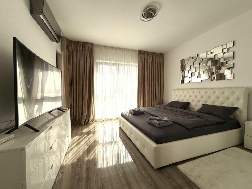 a bedroom with a bed and a flat screen tv at Studio Plaza Faza 2 in Militari