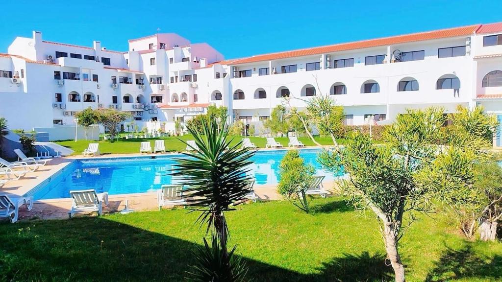 ein großes Gebäude mit einem Swimmingpool davor in der Unterkunft Cozy Apartment in Sagres in Sagres