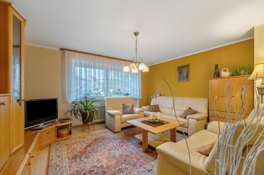 a living room with a couch and a tv at Ferienhaus Störzel - Wohnung A in Hundheim