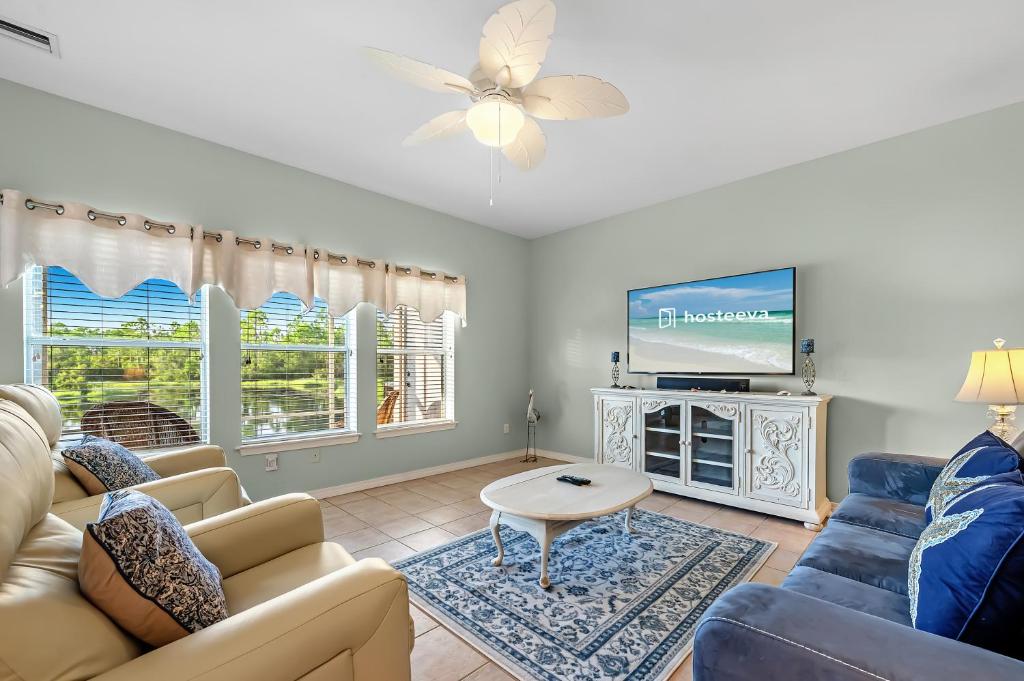 a living room with a couch and a tv at Romar Lakes 104B in Orange Beach