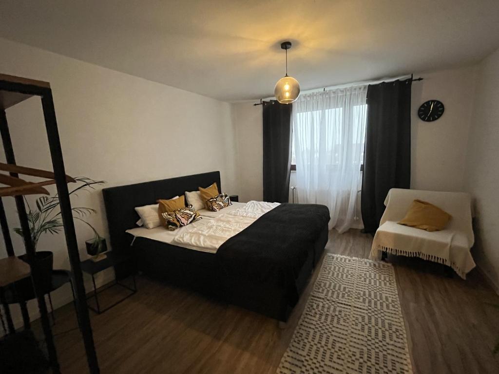 een slaapkamer met een zwart bed en een raam bij Bayreuth Apart No 7 in Bayreuth