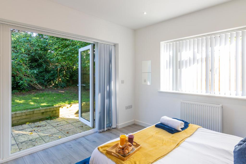 a bedroom with a bed and a large window at The Bluebird Apartment, Built in 2023, 2 minutes walk to JR Hospital & Manor, Ideal for Oxford Brookes University in Oxford