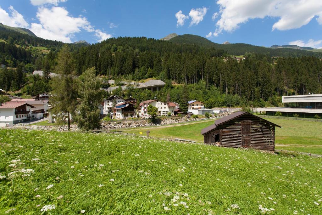 un prato verde con un piccolo edificio su una collina di Hotel Garni DIAS a Kappl