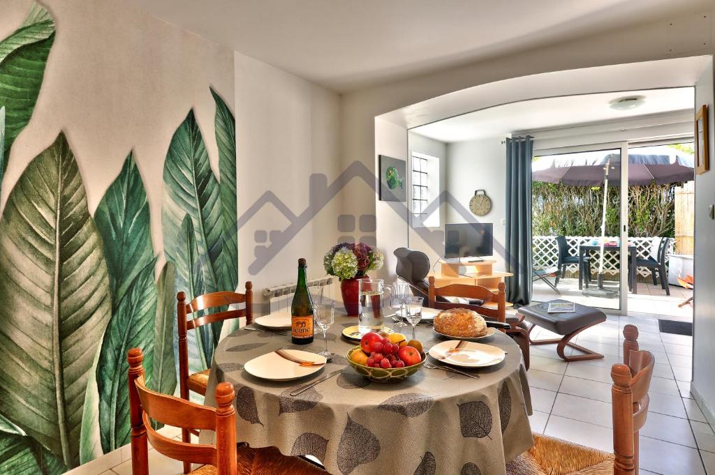 a dining room with a table with a bowl of fruit at LocaLise - A02 - Appartement de plain-pied - terrasse - Juste à côté de la plage - Centre et port à pied - Wifi inclus - Draps inclus - Animaux bienvenus in Tréffiagat