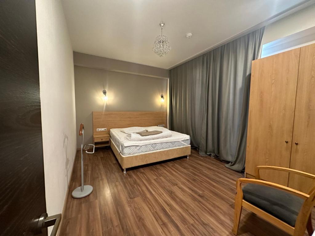 バクリアニにあるBakuriani Inn - Triple Lux #332のベッドと椅子のある寝室