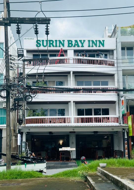 a building with a sunlin bay inn sign on it at Surin Bay Inn in Surin Beach