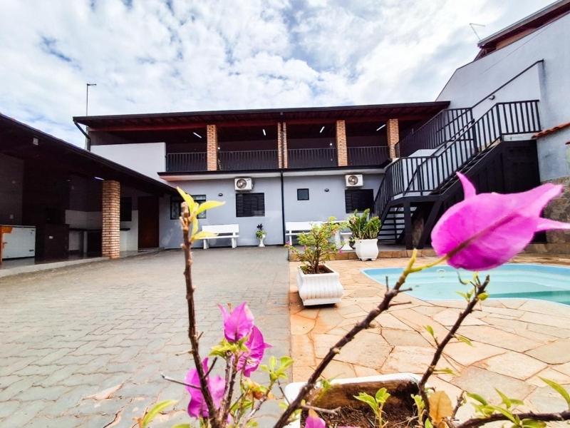 a house with a pink flower in front of it at Casa mana in Olímpia