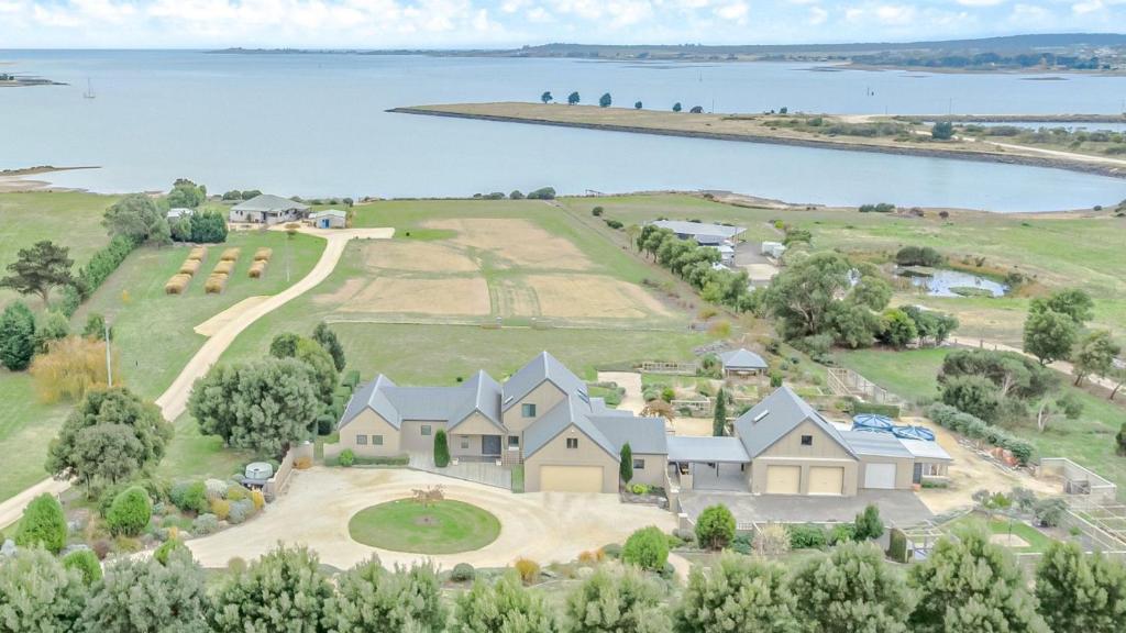 Clarence PointにあるChateau Clarence & Petite Chateau Luxurious Waterfront Retreatの湖を背景とした家屋空見