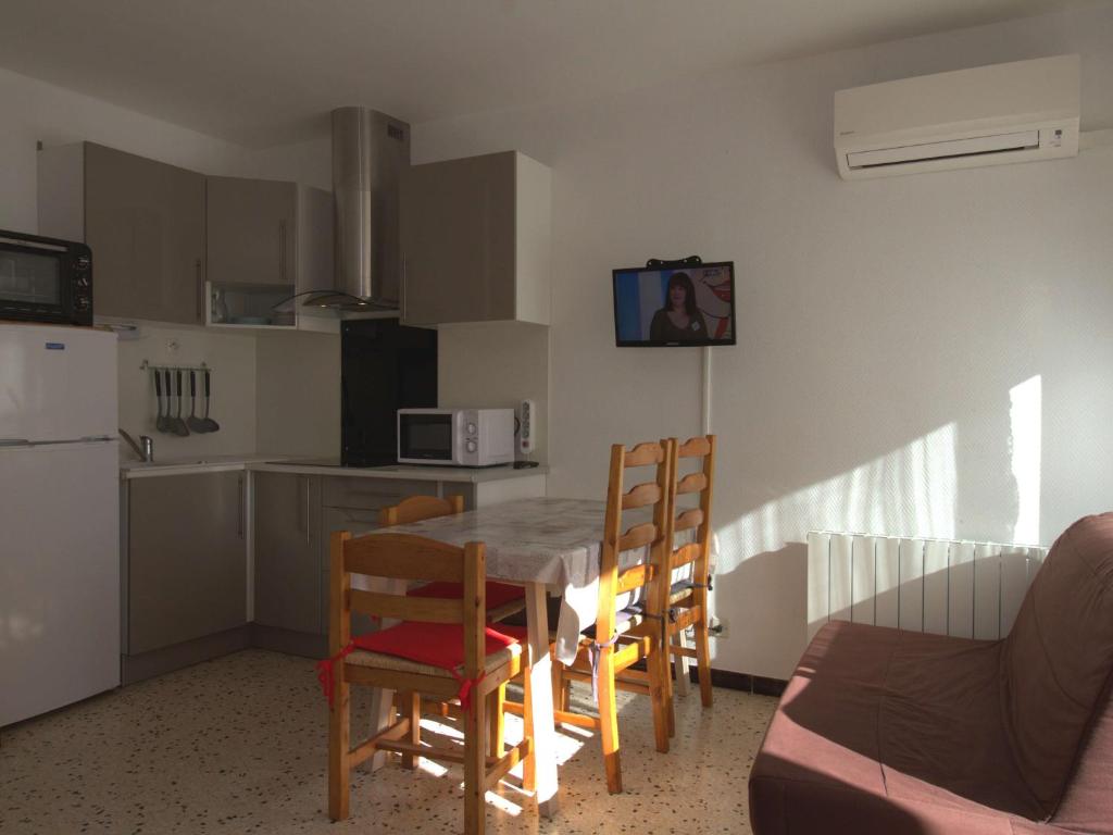une cuisine et une salle à manger avec une table et des chaises dans l'établissement Appartement T1 avec balcon, climatisation et parking près du Parc Charles de Gaulle à Balaruc-les-Bains - FR-1-553-101, à Balaruc-les-Bains