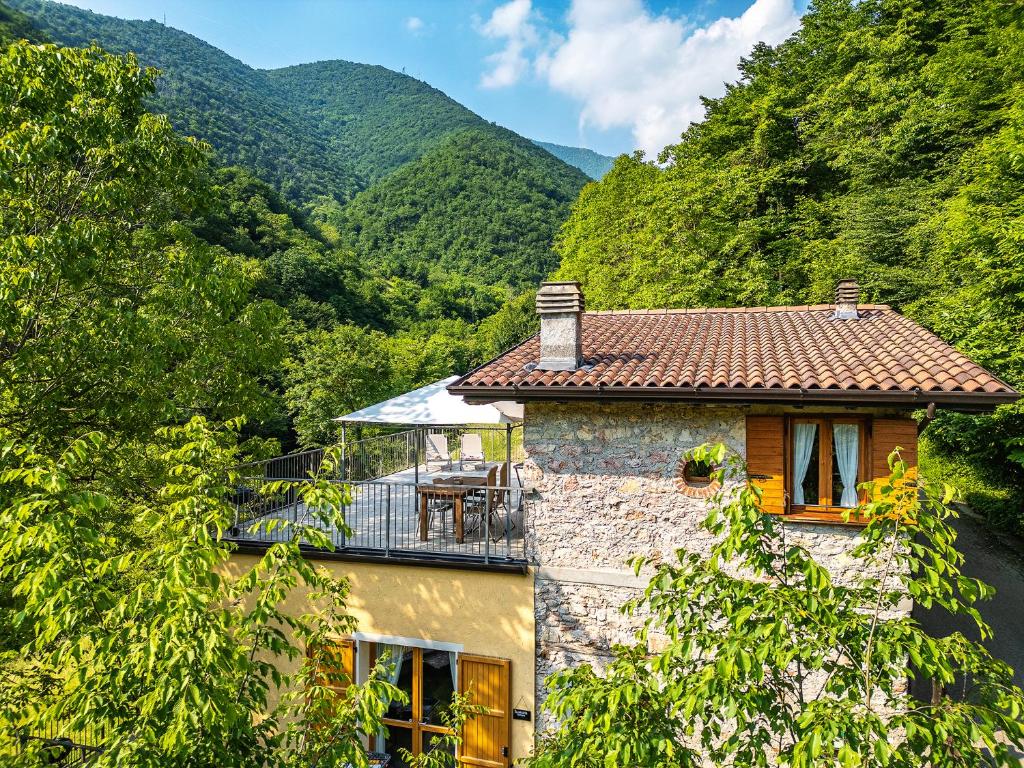 a stone house with a balcony in the mountains at La Fontanina in Vobarno