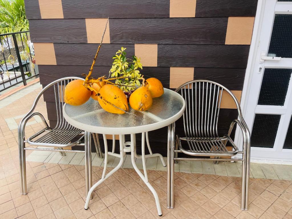 a table with fruit on it with two chairs at Cozy House in Rose Hill