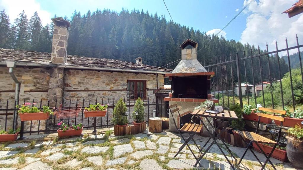 ein Haus mit einem Kamin vor einem Zaun in der Unterkunft Къща за гости Начовата къща, Стойките, община Смолян in Vodata