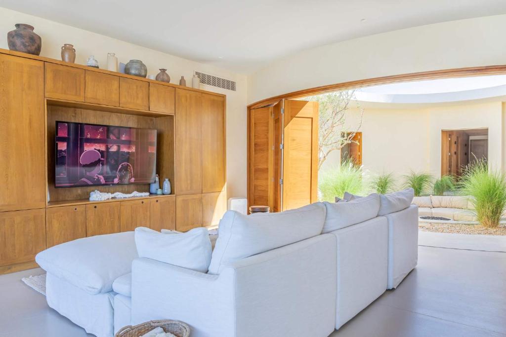Secluded Luxury Beachfront Villa in La Ribera في La Laguna: غرفة معيشة مع أريكة بيضاء وتلفزيون