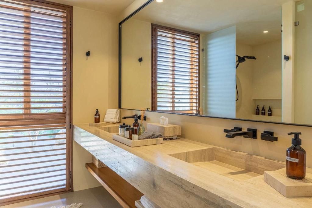 Secluded Luxury Beachfront Villa in La Ribera في La Laguna: حمام به مغسلتين ومرآة كبيرة