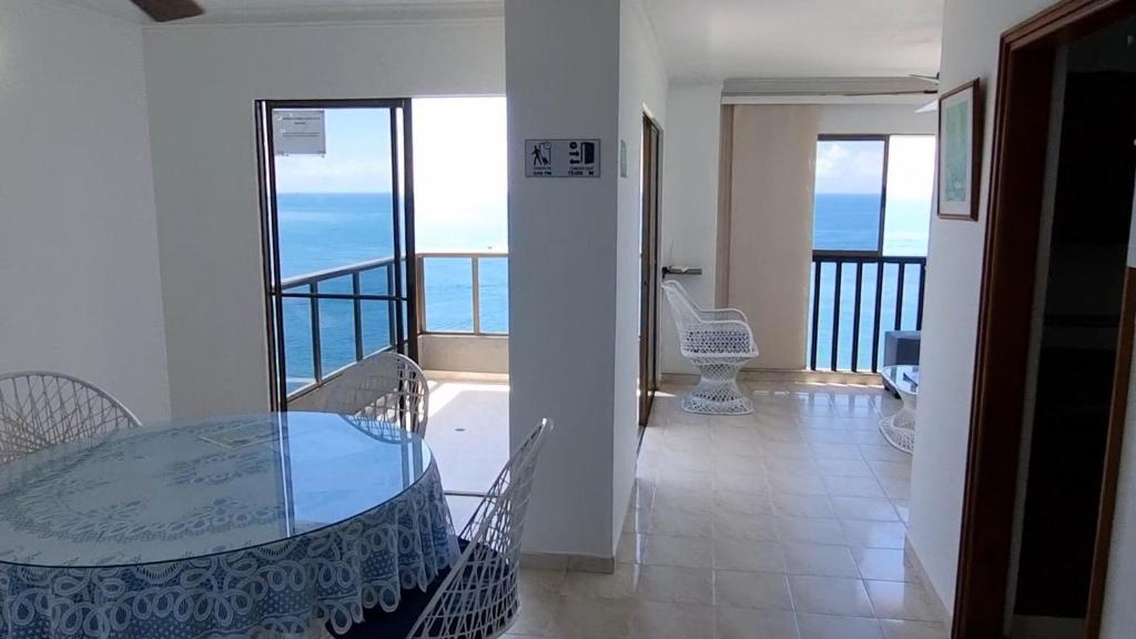 a dining room with a glass table and chairs at apartamento-rodadero-laureles-1601 by reservastodo in Santa Marta