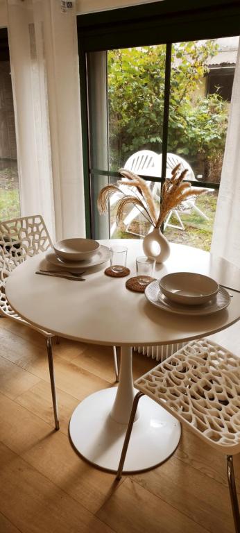 une table avec des assiettes et de la vaisselle en haut dans l'établissement Maisonnette avec jardin - proche Paris - Disney, à Gagny