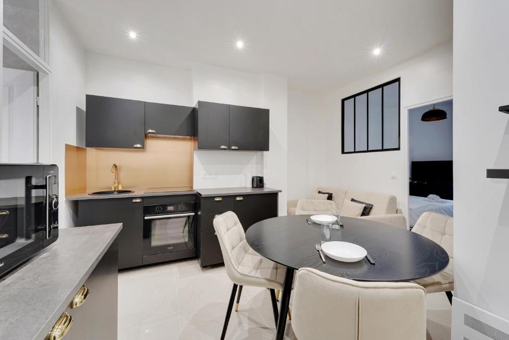 une cuisine et une salle à manger avec une table et des chaises dans l'établissement ODERNER - Cosy apartment, à Paris