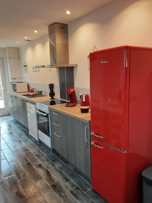 Cette chambre comprend une cuisine équipée d'un réfrigérateur rouge. dans l'établissement Maison individuelle entièrement refaite, à La Ferté-Bernard