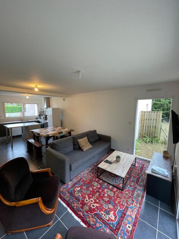 a living room with a couch and a table at LES MAISONS SERENITY Plouzané in Plouzané