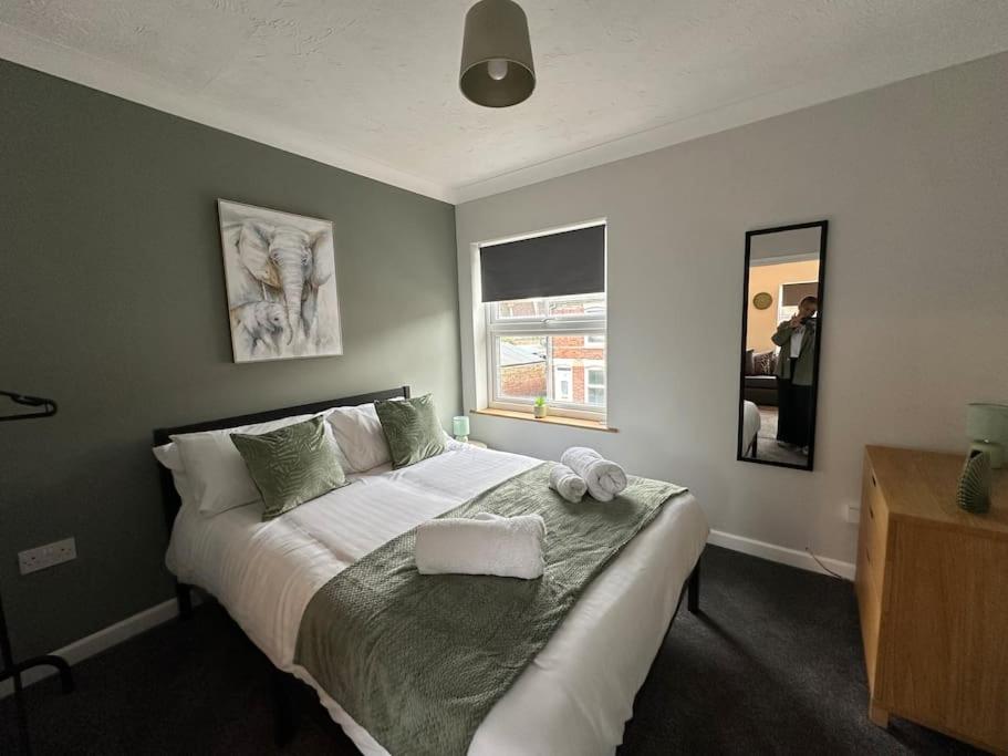 a bedroom with a large white bed with a window at Walnut House - Modern 1 Bedroom Apartment very close to town by Shortstays4u in Kings Lynn